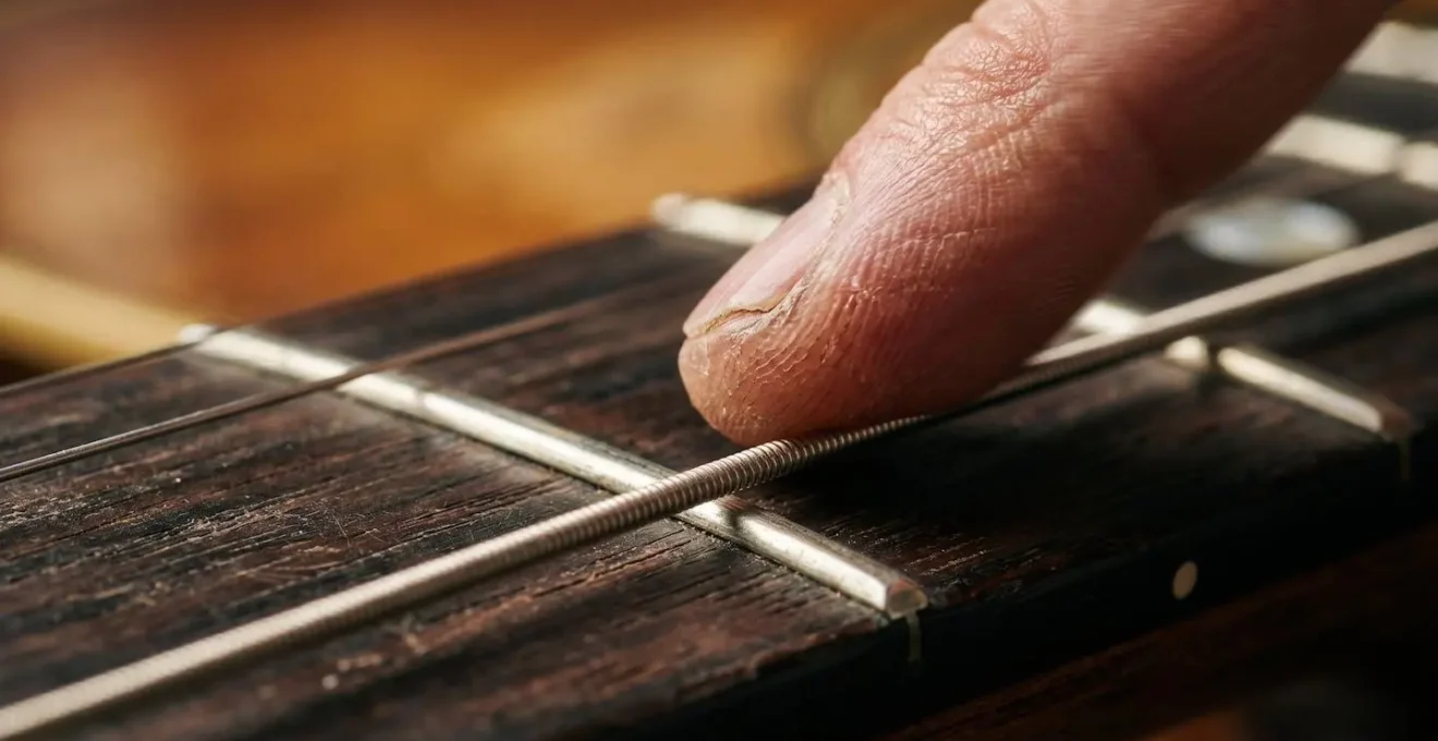Macro detail of guitarist's fingers sliding smoothly between pentatonic positions on fretboard