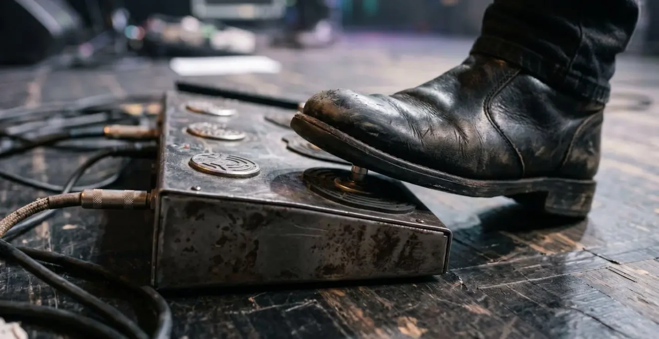 Close-up of a musician's foot operating a MIDI controller pedal during live performance