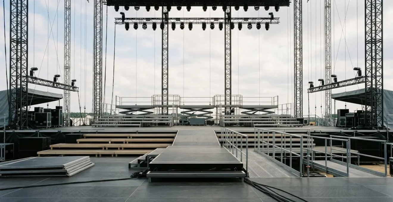 Wide environmental shot of empty festival stage structure showing risers, catwalks, and multiple performance levels