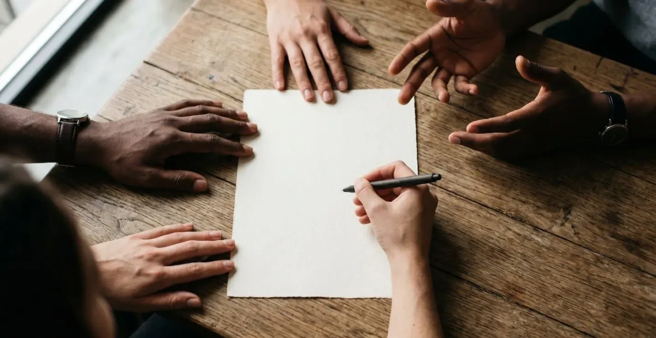 Band members reviewing songwriting agreement in neutral business-like setting