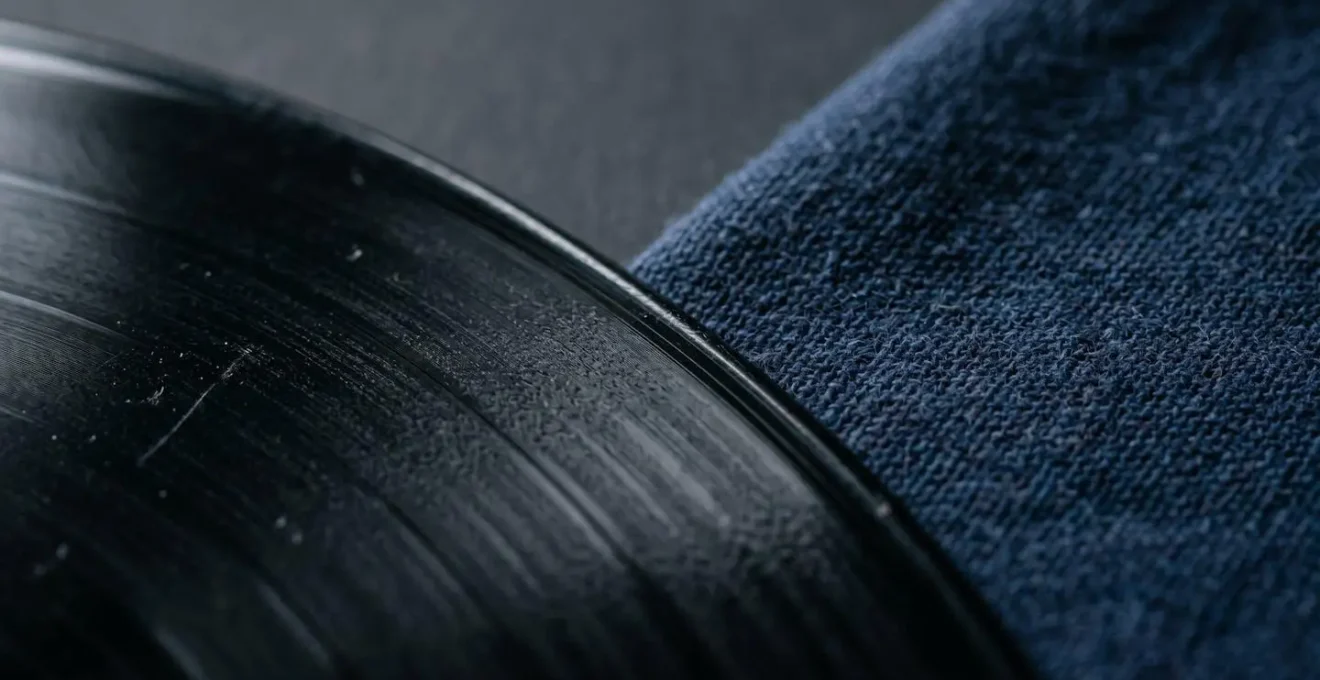 Extreme close-up macro photography of vinyl record grooves and textile fabric textures representing merchandise materials